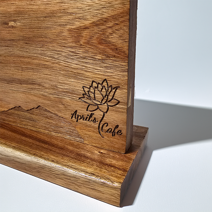 Wooden cutting board with engraved logo and text on a white background