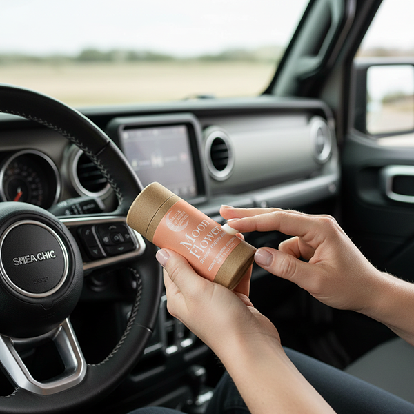 Person holding a Moon Flower Designer Perfume Balm in a car interior